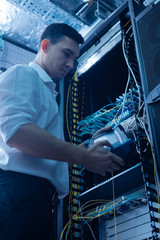 Serious male IT administrator working in the data center