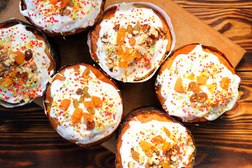 Many eastercake with multi-colored powder and candied fruit for cake on brown wooden boards. Top view.