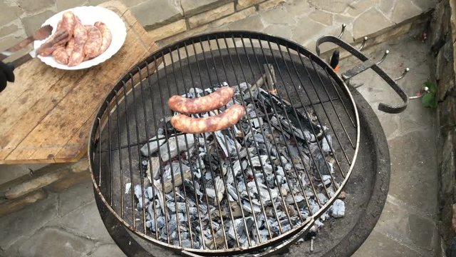 Man arranging sausages on a barbecue