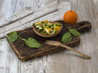 Fruit salad in a wooden plate on a wooden board. 