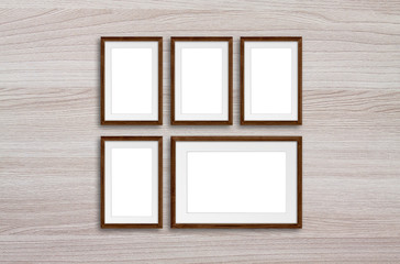 Five photo frames on wooden panels wall