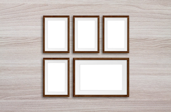 Five photo frames on wooden panels wall
