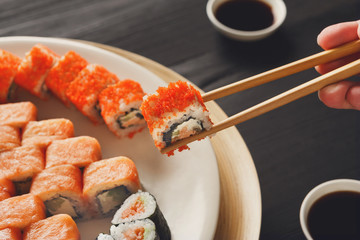 Eating sushi and rolls in japanese restaurant