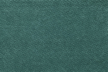Fototapeta na wymiar Dark green fluffy background of soft, fleecy cloth. Texture of light nappy textile, closeup.