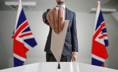 Election or referendum in Great Britain. Voter holds envelope in hand above ballot. United kingdom...