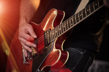 Obraz na płótnie Canvas A rocker is playing guitar on stage.