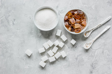 variety of sugar in bowls on gray table background top view
