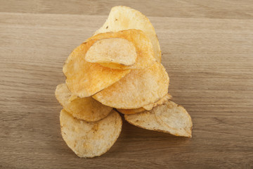 Potato chips on a wooden background