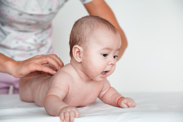 Woman doctor doing baby massage on white background