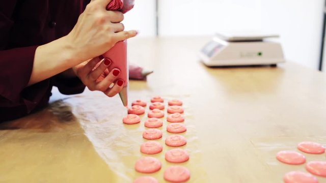 chef with injector squeezing macaron batter