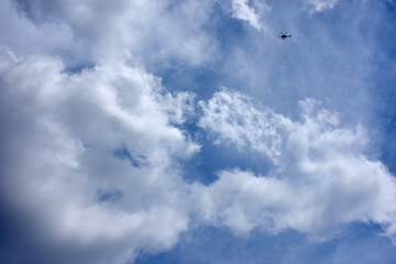 天空を飛ぶヘリコプターと青空と雲「空想・雲のモンスター」子育て、育児、諭す、注意、親子、叱るなどのイメージ、左や下の白い雲部分などにタイトルスペース