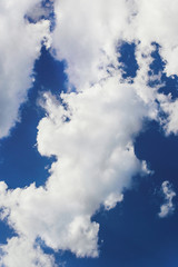 Cumulus clouds against the dark blue sky. Heavenly background.