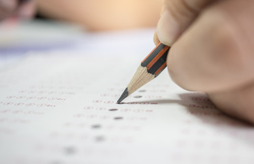 asian hands student testing in exercise, exams answer sheets with color pencil in school