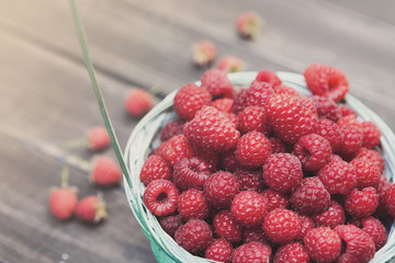 Fresh raspberries basket on brown rustic wood background