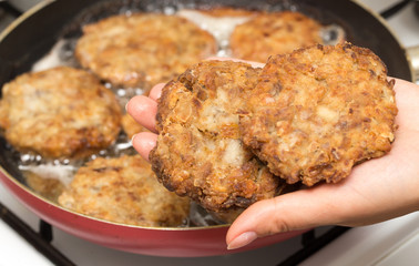 Fried chicken in a frying pan in hand