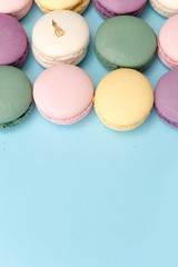 Sweet colorful macaroons on blue table background.