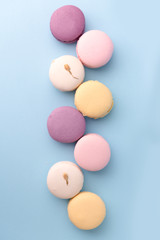 Sweet colorful macaroons on blue table background.