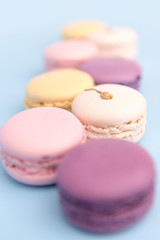 Sweet colorful macaroons on blue table background.
