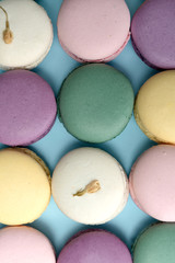 Sweet colorful macaroons on blue table background.