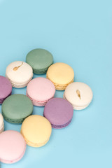 Sweet colorful macaroons on blue table background.