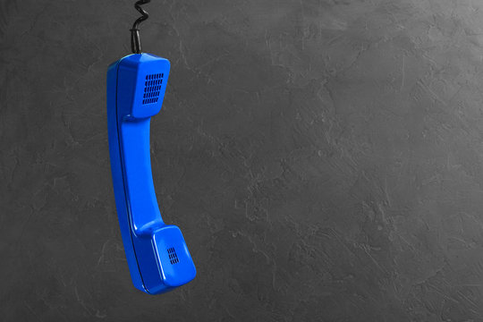 landline blue phone on a gray wall background