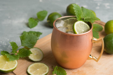 Cold Moscow Mule cocktail in copper mug on the rustic background. Shallow depth of field.