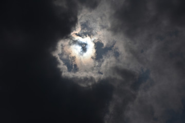 神秘的な光景・雲から透けて見える太陽「空想・じわりと現れはじめたモンスター（太陽が目）」闇（左の黒雲）と光、明暗、誕生、神秘、幻想的、未来からの、お告げなどイメージ。黒雲などにキャッチコピースペース