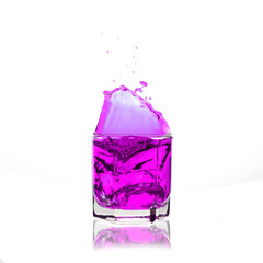 pink cocktail splashing on a glass on white background