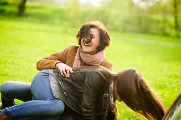 Two pretty young women cheerfully spend time in the spring park.