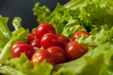 Healthy vegetarian Salad cherry tomatoes and lettuce on the black plate