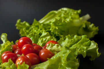 Healthy vegetarian Salad cherry tomatoes and lettuce on the black plate