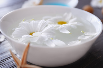 Beautiful spa composition of flowers in bowl with water on table