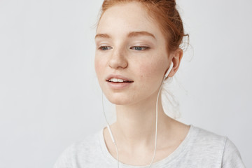 Naklejka premium Closeup of foxy girl listening music in headphones enjoying.