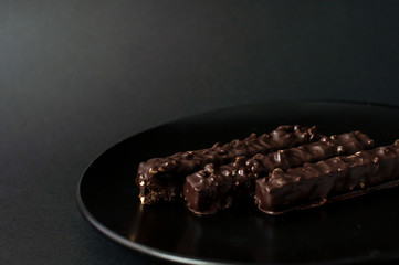Chocolate waffles with nuts on a black background.