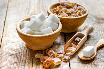 lumps of white and brown sugar on wooden table background