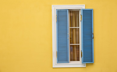 Fototapeta na wymiar Wooden windows on yellow walls