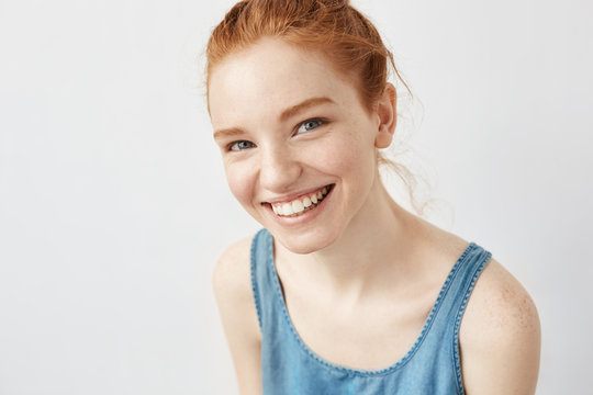Sincere beautiful ginger girl smiling looking at camera.