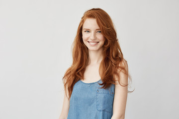 Young attractive redhead girl smiling looking at camera.