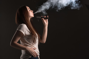 The face of vaping young woman at black studio