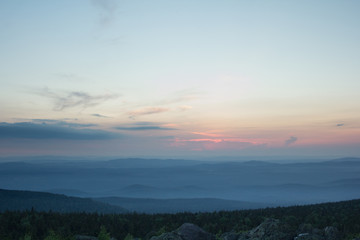 Sunset over the mountainous terrain. The nature of the Southern Urals. Sunset sky over the forest and the mountains.