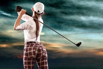 Woman golfer hitting the ball on the sky background. Copy space. Ad concept.