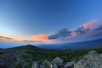 Sunset over the mountainous terrain. The nature of the Southern Urals. Sunset sky over the forest and the mountains.