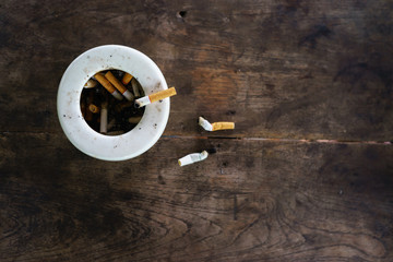 cigarette with ashtray on wood table.