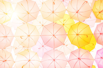 Lots of colorful umbrellas flying in sky over city street during summer festival. Fun and happy background concept. Vintage and retro threme.