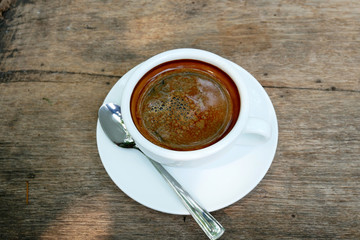 Cup of fresh coffee on wooden background, top view