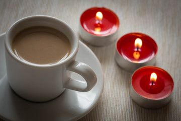 Fototapeta na wymiar Homemade cup of coffee surrounded by candles / hygge time