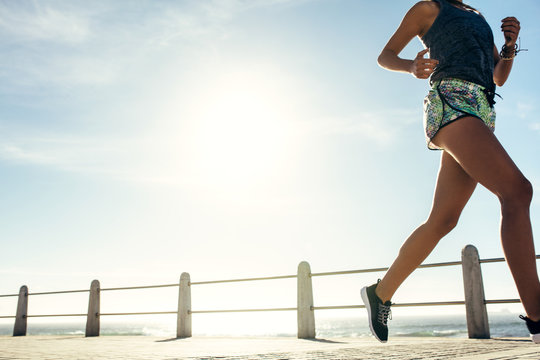 Fitness woman running on ocean front