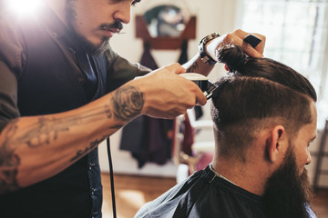Homme se coupe de cheveux à la mode dans un salon de coiffure