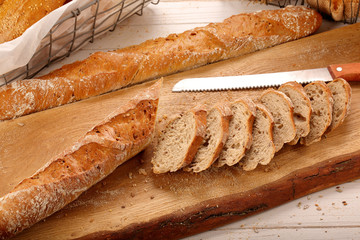 Fresh baguettes in bakery on wooden background