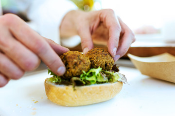 Chef preparing bread with meatballs in a food truck.